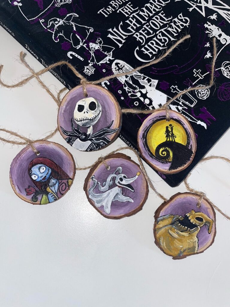 Image of 5 wooden Nightmare before Christmas themed decorations set against a book
